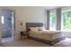 Bright bedroom featuring a cozy bed, bedside tables, and views of the backyard at 4710 Old Pageland Marshville Rd, Monroe, NC 28112
