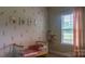 Charming Bedroom with leaf pattern wallpaper and a crib with coordinating soft furnishings at 4710 Old Pageland Marshville Rd, Monroe, NC 28112