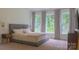 Well-lit primary bedroom showcasing a bed and windows that provide views of the backyard at 4710 Old Pageland Marshville Rd, Monroe, NC 28112