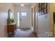 Inviting foyer with a stylish console table, oval mirror, decorative rug, and a bright, white front door with sidelight at 4710 Old Pageland Marshville Rd, Monroe, NC 28112