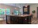 Spacious island with dishwasher, undermount sink and faucet, and bar stool seating, connecting to a dining area and fireplace at 4710 Old Pageland Marshville Rd, Monroe, NC 28112