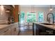 Kitchen with an island, pendant lights, stainless appliances, modern lighting, and a dining area with views of the backyard at 4710 Old Pageland Marshville Rd, Monroe, NC 28112