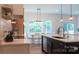 Bright kitchen featuring an island with seating, pendant lights, stainless appliances, and a view to the backyard at 4710 Old Pageland Marshville Rd, Monroe, NC 28112