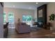 Bright living room with wood floors, a cozy fireplace, comfortable seating, large windows, and access to the outdoor deck at 4710 Old Pageland Marshville Rd, Monroe, NC 28112