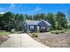 A long driveway leads to a beautifully landscaped blue home with vibrant flowers and a convenient storage shed at 5016 Old Pine Ln, Cherryville, NC 28021