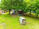Spacious backyard with mature trees, with visible deck and a peek of the house in the background at 504 Amon Ln, Pineville, NC 28134