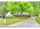 Ranch-style home with mature trees, long driveway, and well-maintained lawn at 504 Amon Ln, Pineville, NC 28134