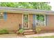 Charming brick home entrance with decorative door, blue shutters and flower urns at 504 Amon Ln, Pineville, NC 28134