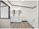 Bright bathroom featuring a double vanity, round mirrors, and a soaking tub at 6085 Faith Rd, Salisbury, NC 28146