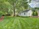 Expansive backyard with lush green grass and brick home in the background at 6116 Springhouse Ln, Charlotte, NC 28211