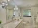Bright bathroom with marble countertop vanity, modern fixtures, and a glass enclosed shower at 6116 Springhouse Ln, Charlotte, NC 28211