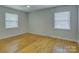 Bright bedroom with hardwood floors, two windows, ceiling fan and neutral paint at 6116 Springhouse Ln, Charlotte, NC 28211