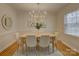 Bright dining room with an elegant chandelier, hardwood floors, and a view to the living room at 6116 Springhouse Ln, Charlotte, NC 28211