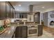 Updated kitchen with granite countertops, stainless steel appliances, dark wood cabinets and a gas range stove at 6116 Springhouse Ln, Charlotte, NC 28211
