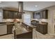 Kitchen featuring a gas range, granite counters, stainless appliances, dark wood cabinets, and under cabinet lighting at 6116 Springhouse Ln, Charlotte, NC 28211