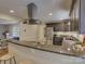 Open-concept kitchen featuring granite counters, stainless appliances, dark wood cabinets, and a peninsula counter with seating at 6116 Springhouse Ln, Charlotte, NC 28211