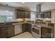 Updated kitchen with granite countertops, stainless steel appliances, dark wood cabinets, tile floors and modern fixtures at 6116 Springhouse Ln, Charlotte, NC 28211