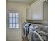 Well-equipped laundry room with side-by-side washer and dryer, storage, and exterior access at 6116 Springhouse Ln, Charlotte, NC 28211