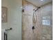 Beautiful, tiled shower with glass door, built-in seat, and modern shower head at 6116 Springhouse Ln, Charlotte, NC 28211