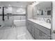 Elegant bathroom features a freestanding tub, glass shower, and gray double vanity with marble countertops at 6400 Morningsong Ln, Charlotte, NC 28269