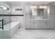 Contemporary bathroom showcasing gray double vanity, elegant freestanding tub, and glass enclosed shower at 6400 Morningsong Ln, Charlotte, NC 28269