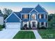 Beautiful two-story home featuring a manicured lawn, attached two-car garage and classic architectural details at 6400 Morningsong Ln, Charlotte, NC 28269