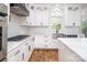 Modern kitchen with white cabinets, stainless steel appliances, a marble countertop, and an arched window at 6400 Morningsong Ln, Charlotte, NC 28269