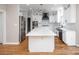 Spacious kitchen with white cabinets, stainless steel appliances, center island with marble countertop and hardwood floors at 6400 Morningsong Ln, Charlotte, NC 28269