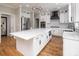 Expansive kitchen featuring an island, white cabinetry, stainless steel appliances, modern fixtures, and hardwood flooring at 6400 Morningsong Ln, Charlotte, NC 28269