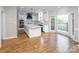 A spacious kitchen with white cabinets, an island and modern stainless steel appliances and hardwood floors at 6400 Morningsong Ln, Charlotte, NC 28269