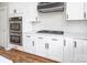 Close up shot of a kitchen featuring modern stainless steel appliances, white countertops and white cabinets at 6400 Morningsong Ln, Charlotte, NC 28269