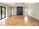 Bright living room features hardwood floors, a coffered ceiling, and a modern fireplace at 6400 Morningsong Ln, Charlotte, NC 28269