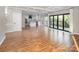 Open concept living area with hardwood floors, adjacent to staircase, kitchen, and deck access at 6400 Morningsong Ln, Charlotte, NC 28269