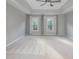 Bright main bedroom featuring a tray ceiling, ceiling fan, and two large windows at 6400 Morningsong Ln, Charlotte, NC 28269