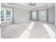Spacious main bedroom with neutral carpet, tray ceiling, ceiling fan, and large windows at 6400 Morningsong Ln, Charlotte, NC 28269