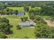 Picturesque aerial view of a home with a pond, surrounded by lush greenery and mature trees at 714 Helms Efird Rd, Marshville, NC 28103
