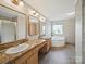 Traditional bathroom with dual sinks, a soaking tub, and a separate glass-enclosed shower at 714 Helms Efird Rd, Marshville, NC 28103