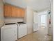 Bright laundry room with washer, dryer, and wooden cabinets for storage at 714 Helms Efird Rd, Marshville, NC 28103