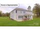 Expansive backyard featuring a stone outdoor kitchen, patio, and lush lawn, ideal for outdoor living at 7184 Sylvan Retreat Dr, Denver, NC 28037
