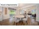 Bright dining area open to the living room featuring a modern light fixture and sliding door to the backyard at 7184 Sylvan Retreat Dr, Denver, NC 28037