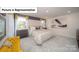 Carpeted main bedroom features a large bed, neutral walls, and large window at 7184 Sylvan Retreat Dr, Denver, NC 28037