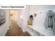 Well-lit mudroom featuring a bench with storage cubbies, coat hooks, and hardwood floors throughout at 7184 Sylvan Retreat Dr, Denver, NC 28037