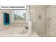 Relaxing bathroom with soaking tub and tiled shower area, brightened by natural light at 7196 Sylvan Retreat Dr, Denver, NC 28037