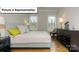 Stylishly staged bedroom with wood flooring, decor and natural light at 7196 Sylvan Retreat Dr, Denver, NC 28037