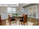 Elegant dining room featuring a glass-top table, hardwood floors, and natural light from the window at 7196 Sylvan Retreat Dr, Denver, NC 28037