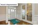 Bright foyer featuring hardwood floors, elegant trim work, and glass-paneled french doors leading to another room at 7196 Sylvan Retreat Dr, Denver, NC 28037
