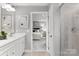 Bathroom showcasing a double vanity with stone countertops, a walk-in shower and an adjoining bedroom at 7332 Childress Dr, Concord, NC 28025