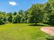 Large, well-manicured backyard with a brick patio area, perfect for outdoor entertaining and recreation at 7356 Terrace Dr, Charlotte, NC 28211