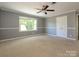 Bedroom featuring a ceiling fan, a window for natural light, and a double-door closet at 7356 Terrace Dr, Charlotte, NC 28211