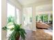 Living room featuring large windows with an adjacent staircase and a comfortable pink chaise lounge at 7356 Terrace Dr, Charlotte, NC 28211